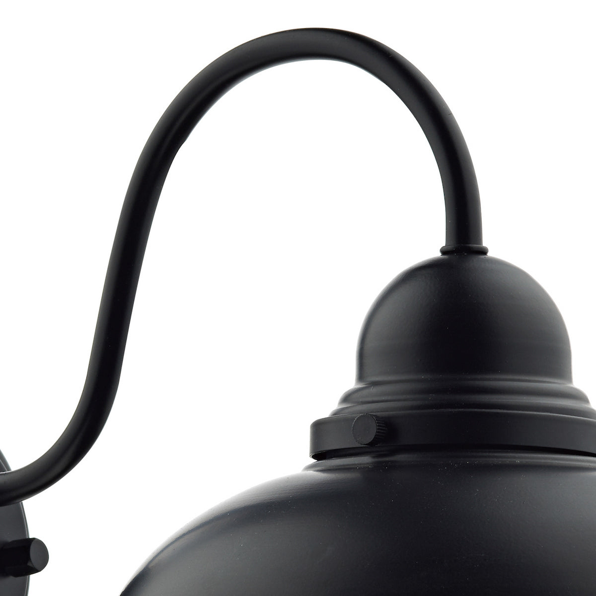 Close up of a black metal outdoor wall light with a curved arm and a dome-shaped shade