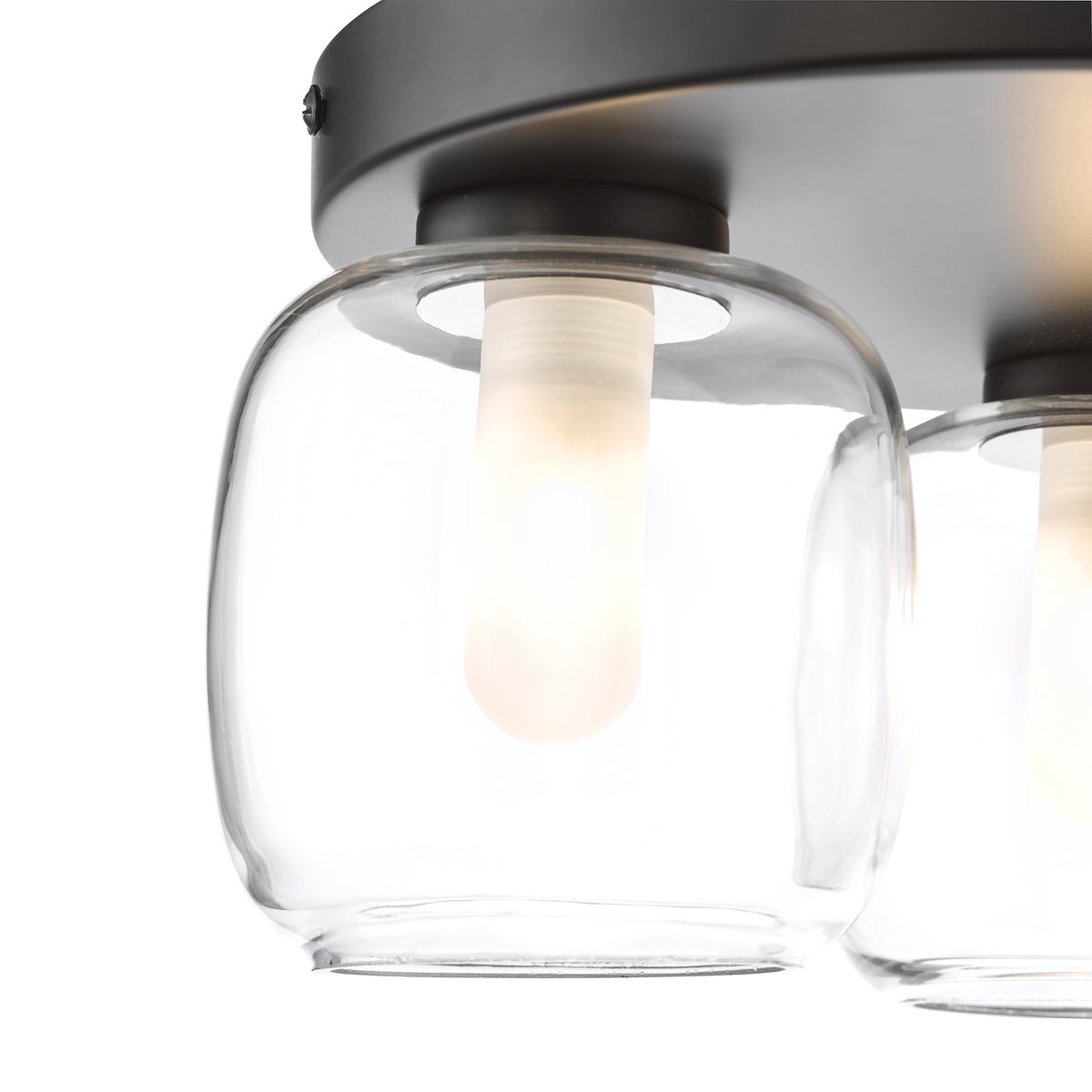 Close-up of a black ceiling light fixture with two clear glass shades and glowing bulbs