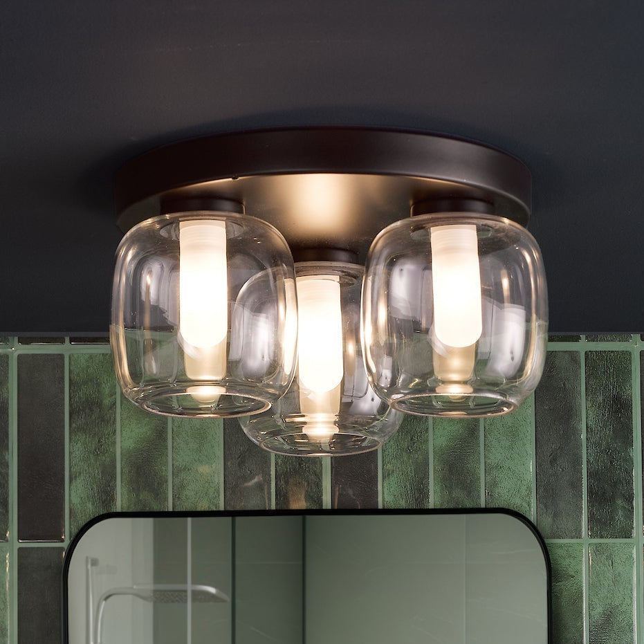 Three light ceiling fixture with clear glass shades and a dark bronze base