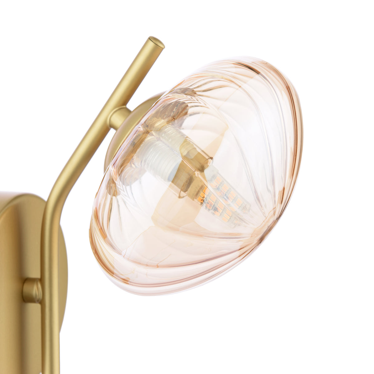 Close up of a gold wall sconce with a ribbed amber glass shade and an exposed LED bulb