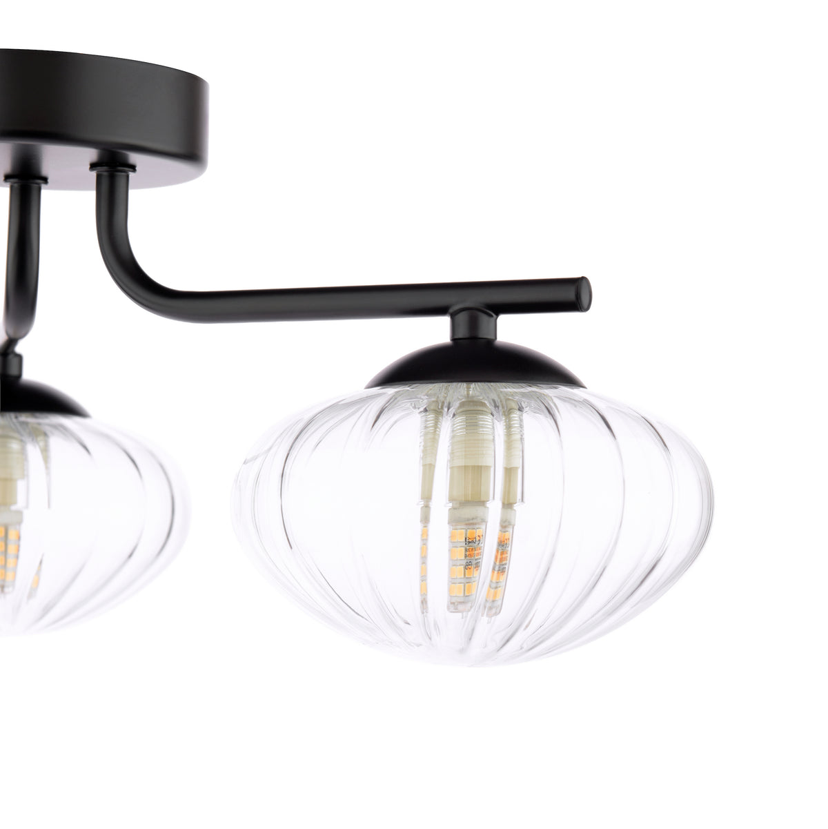 Close up of a black ceiling light with two clear, ribbed glass shades and exposed LED bulbs