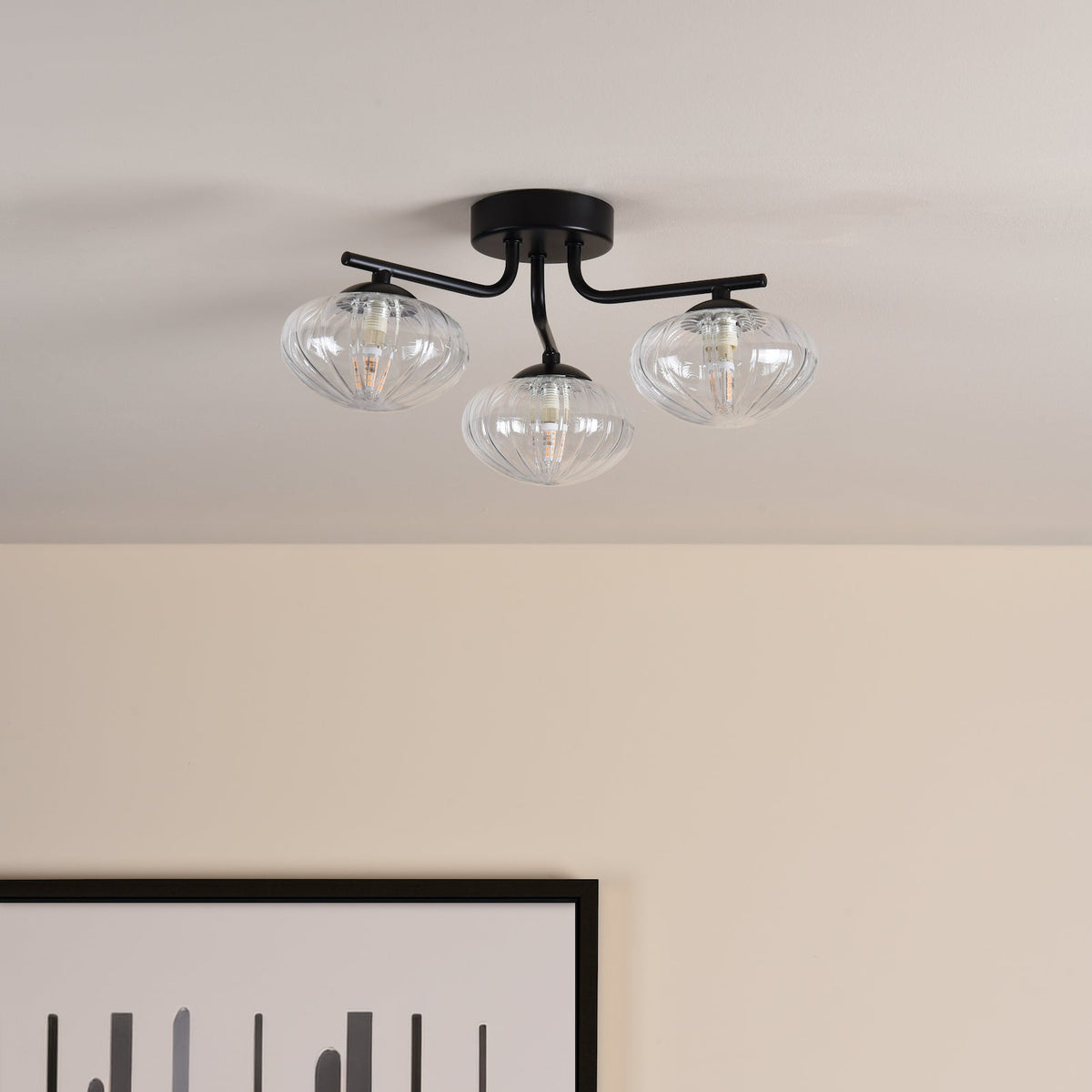Black three-arm ceiling light with ribbed glass shades