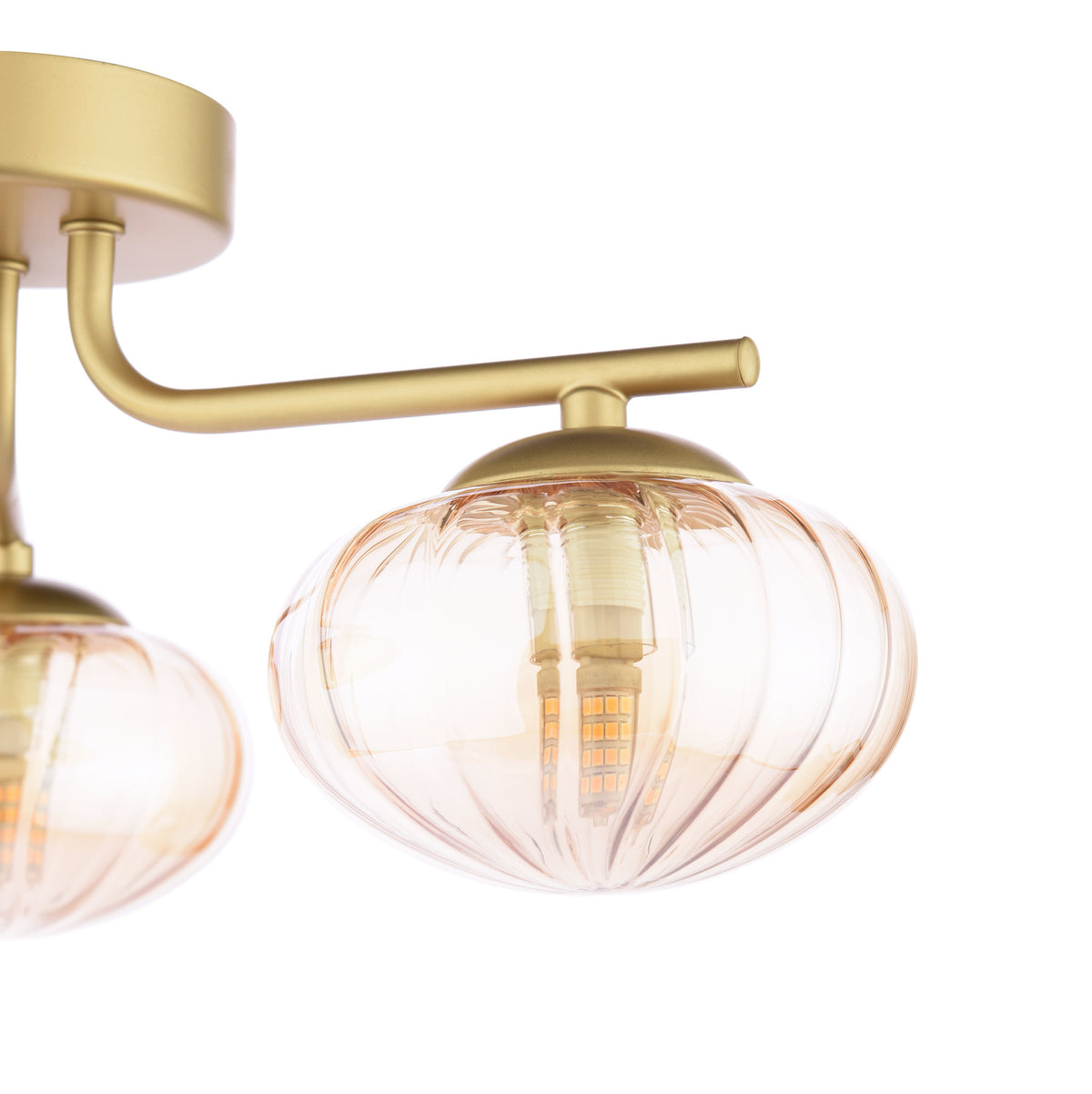 Close up of a gold ceiling light with two amber fluted glass shades