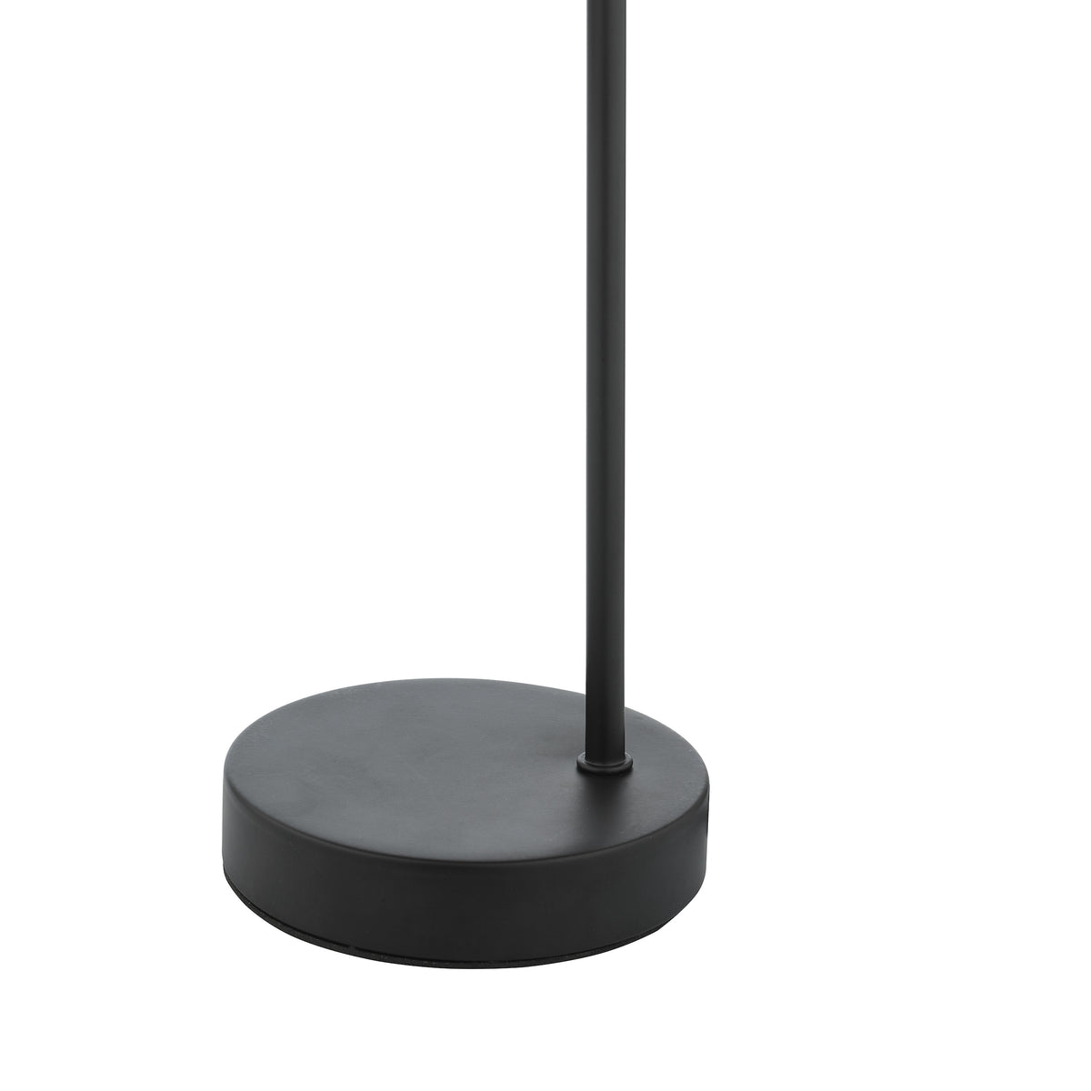 Black round base of a floor lamp with a thin black pole extending upwards