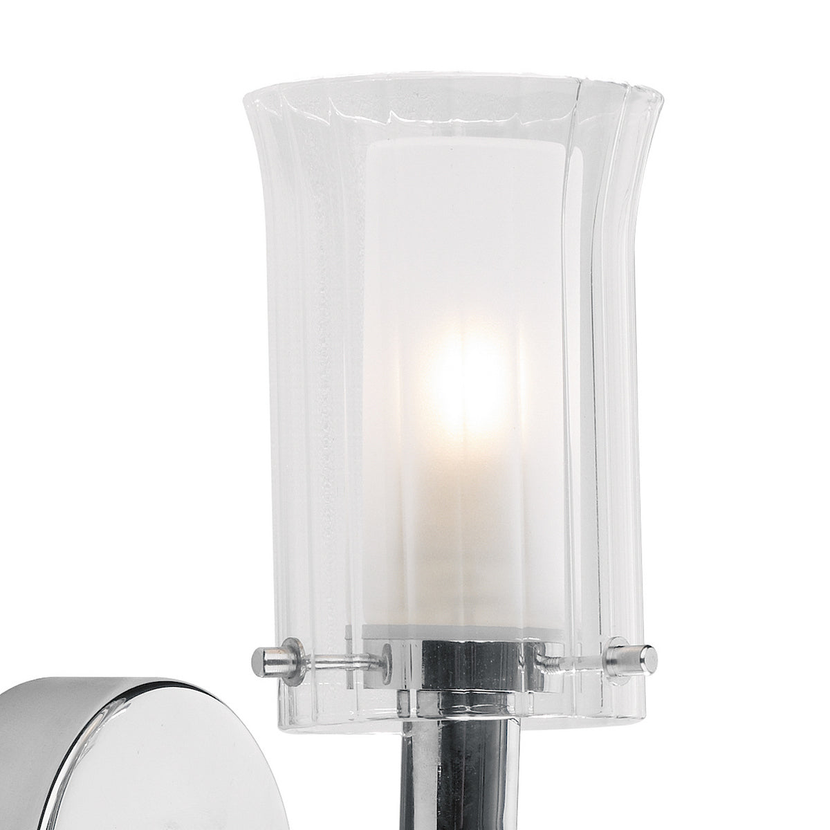 Close-up of a wall light with a clear glass shade and a frosted inner diffuser, glowing brightly.