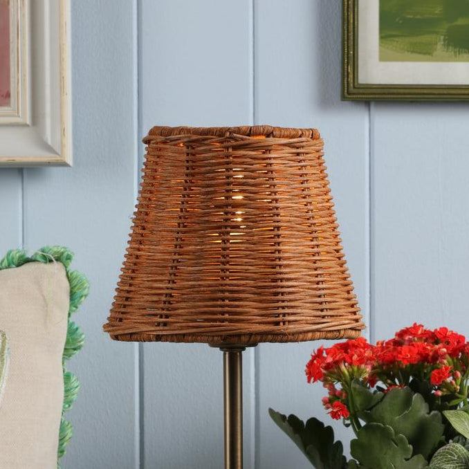 Woven rattan lamp shade on a metal stand