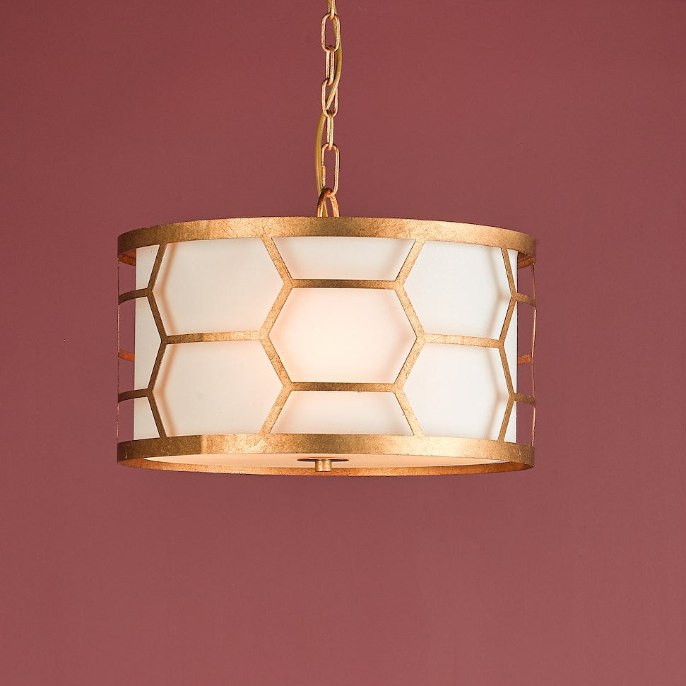 Gold pendant light with a white drum shade and a honeycomb pattern