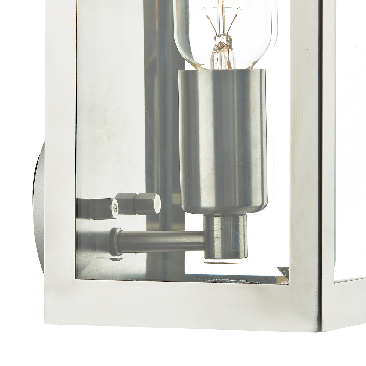 Close-up of a brushed nickel outdoor wall light with clear glass panels and an exposed bulb.