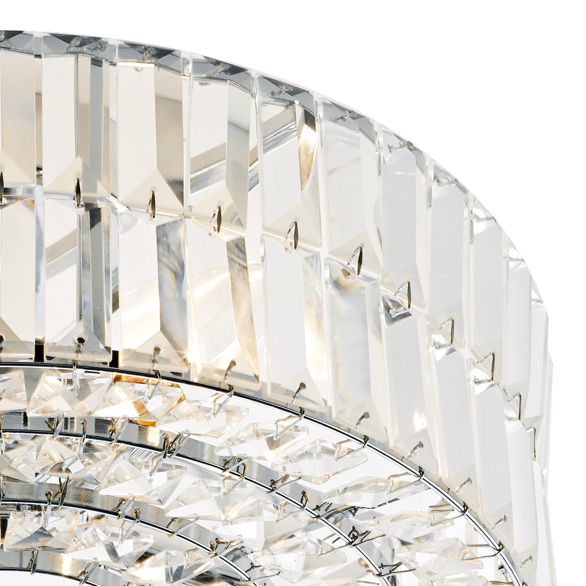 Close-up of a crystal chandelier with rectangular and triangular prisms reflecting light.