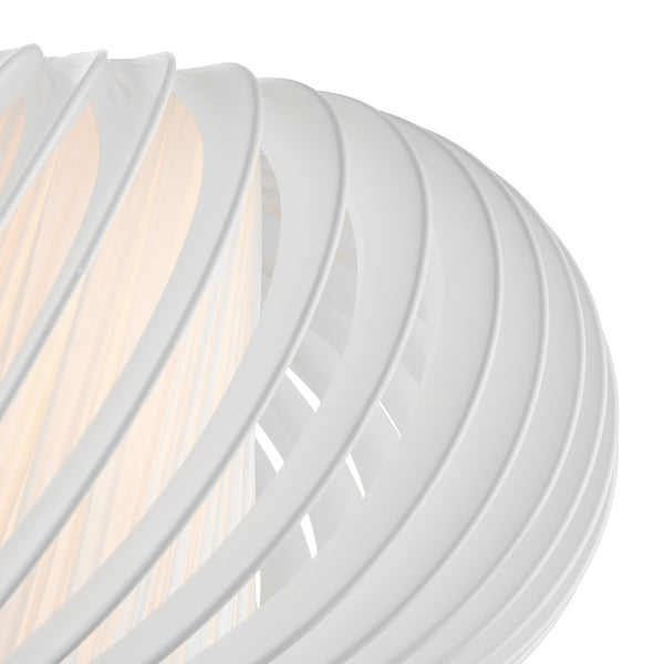Close-up of a white, spiraled lampshade with a warm glow emanating from within.