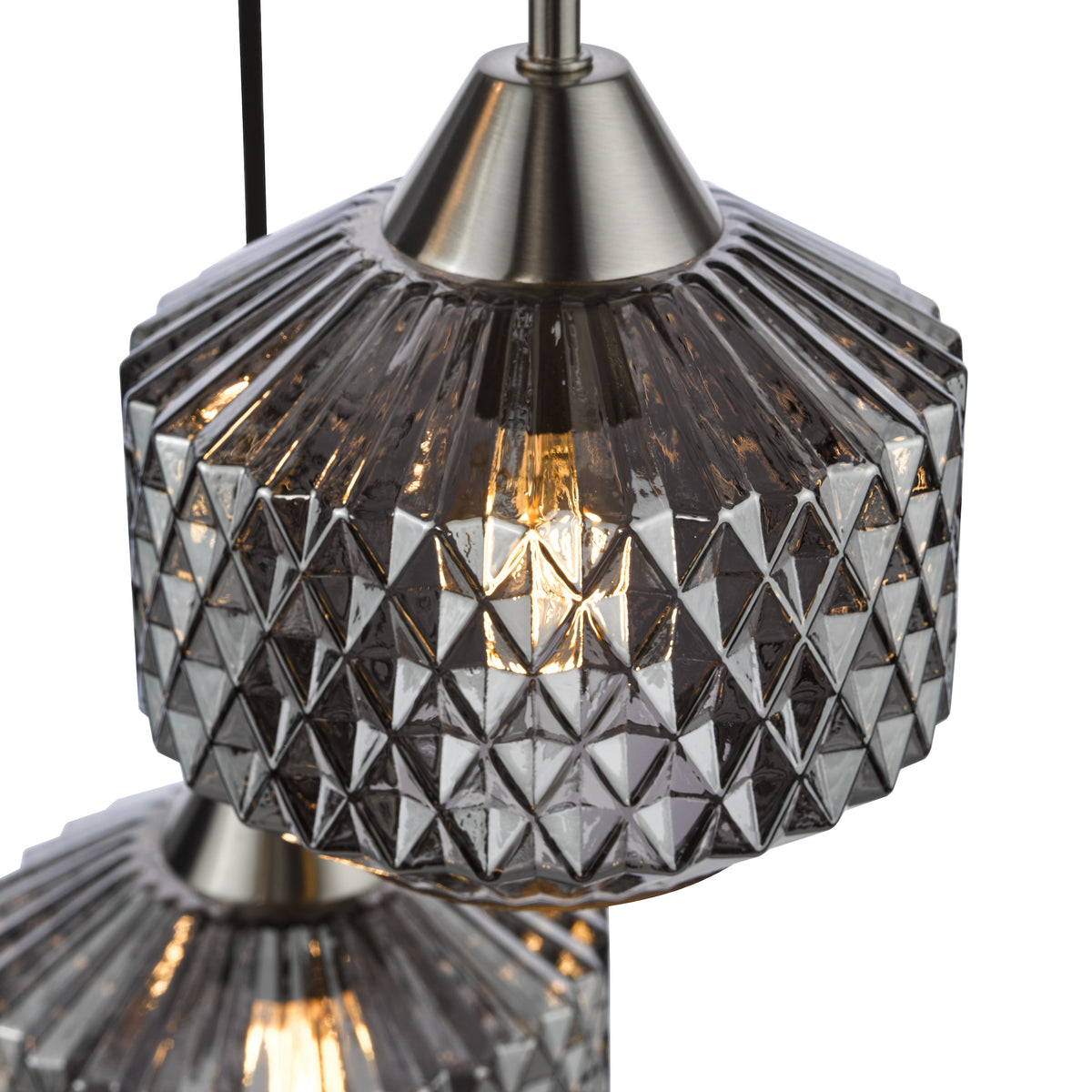 Close up of a pendant light with a textured glass shade and a brushed nickel top