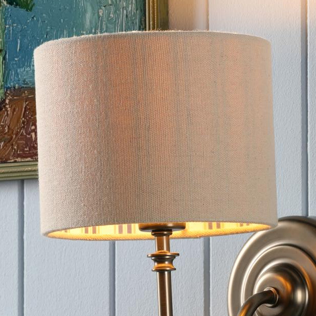 Joules Farley wall light in satin bronze with a natural linen drum shade