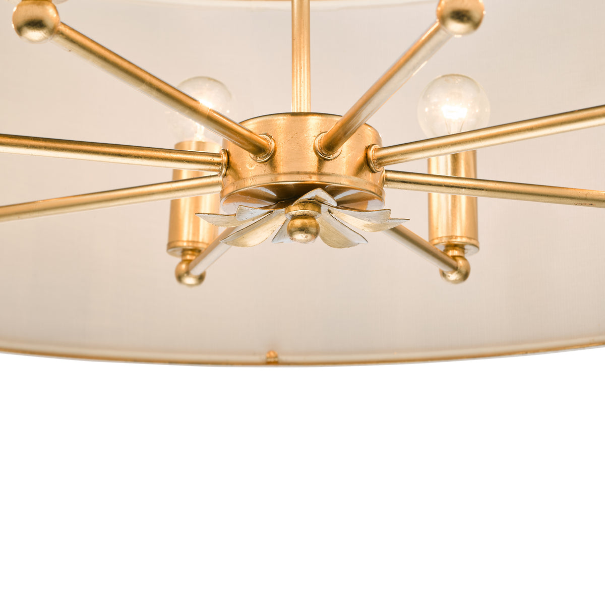 Close up of a gold chandelier with light bulbs and a white fabric shade