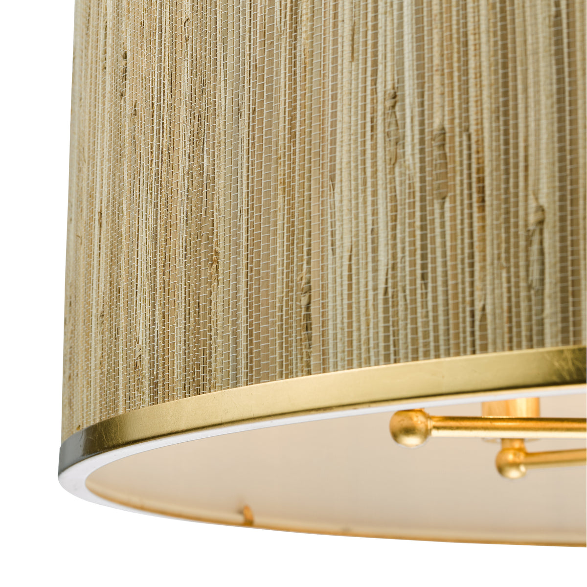 Close-up of a cylindrical lamp shade with a woven straw texture and a gold band at the bottom