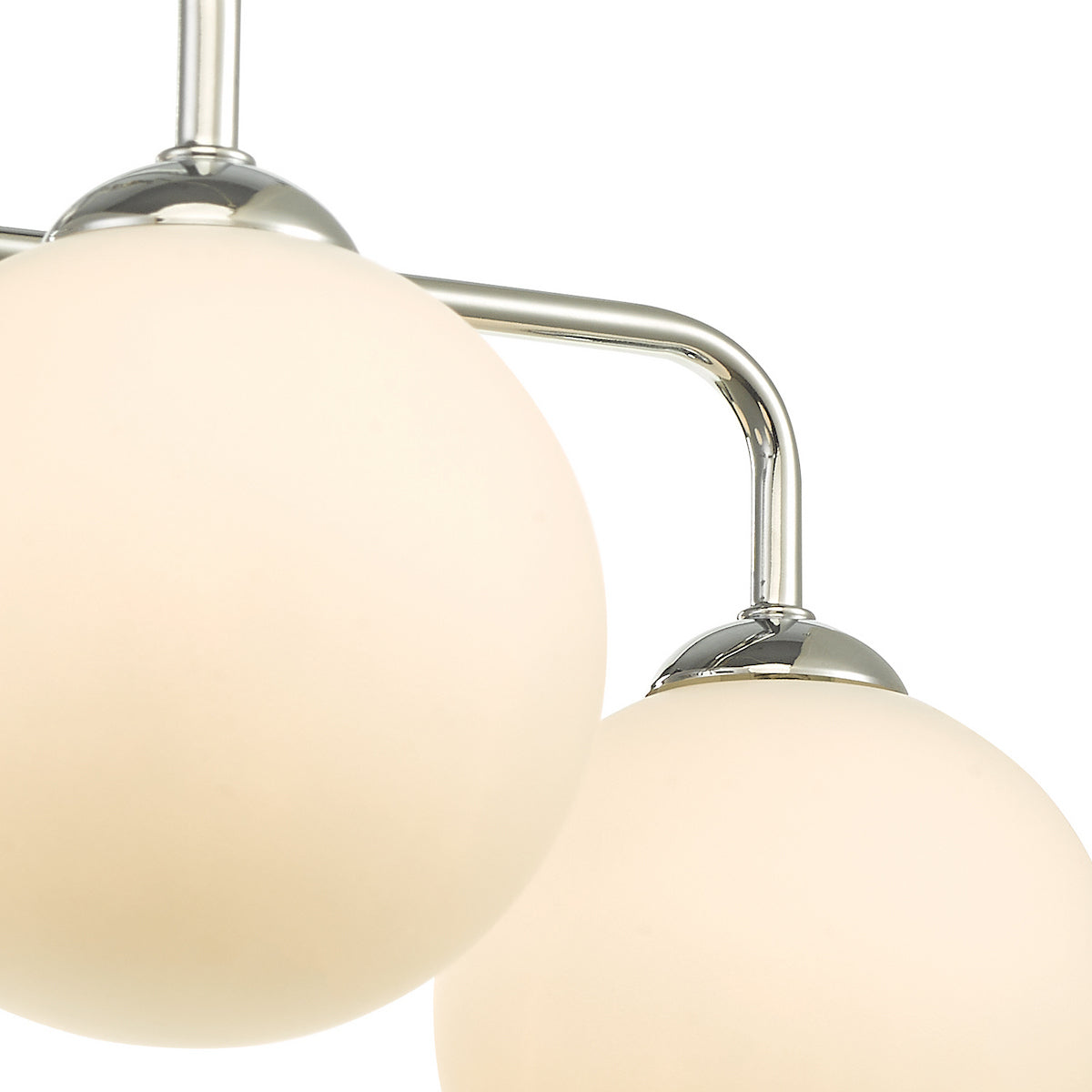 Close-up of a modern light fixture with three frosted globe shades and polished chrome accents.