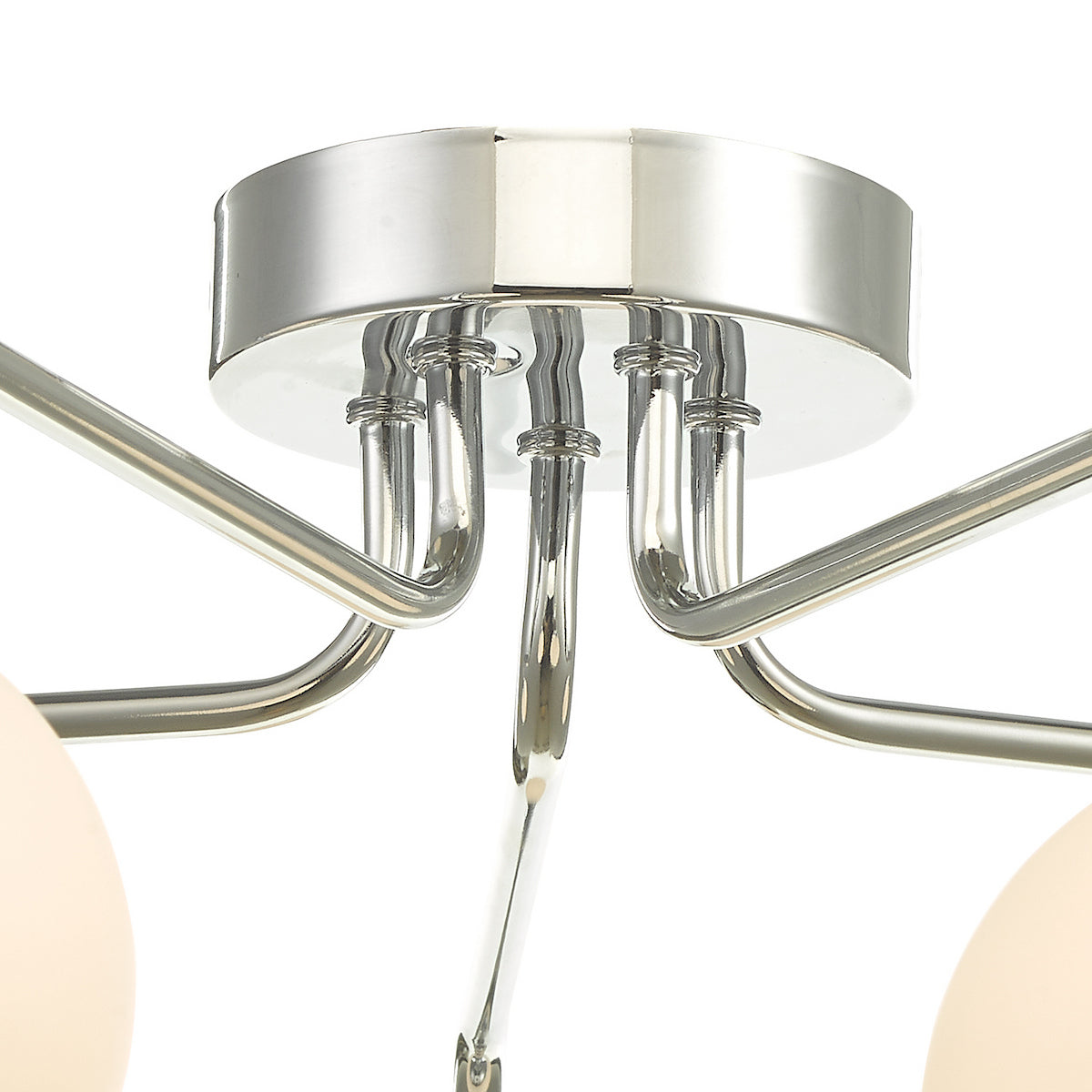 Close-up of a modern ceiling light fixture with chrome finish and curved arms.