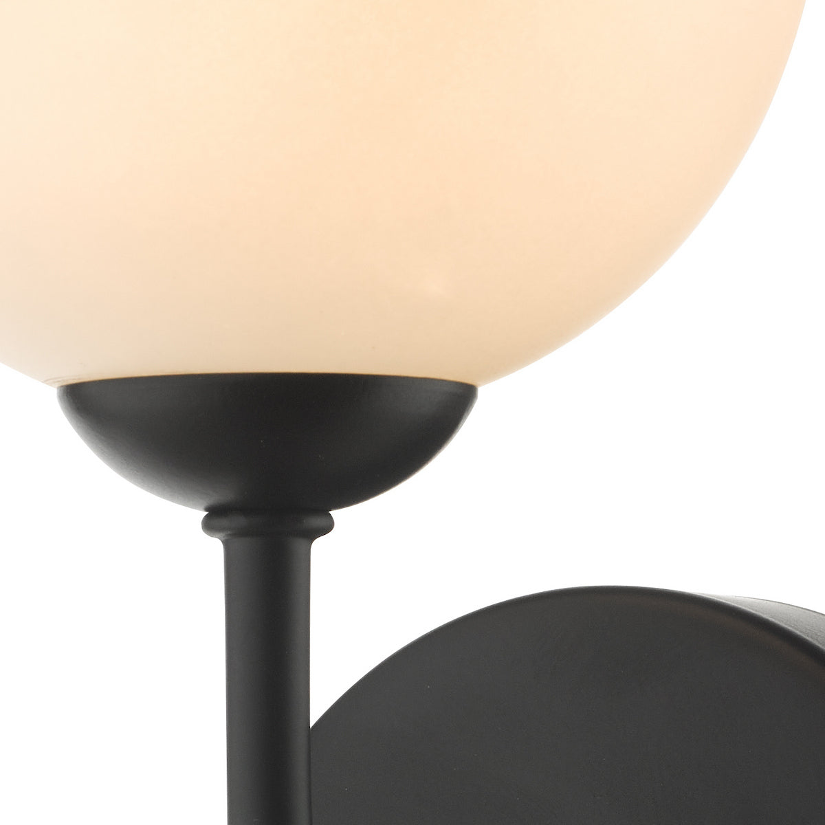 Close-up of a black wall sconce with a cream-colored globe light.