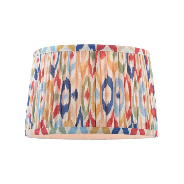 Drum lampshade with a colorful ikat pattern in red blue yellow and green on a cream background