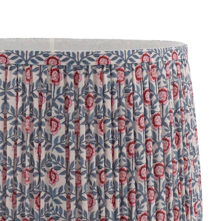 Pleated lampshade with pink floral and blue leaf block print pattern on cream background