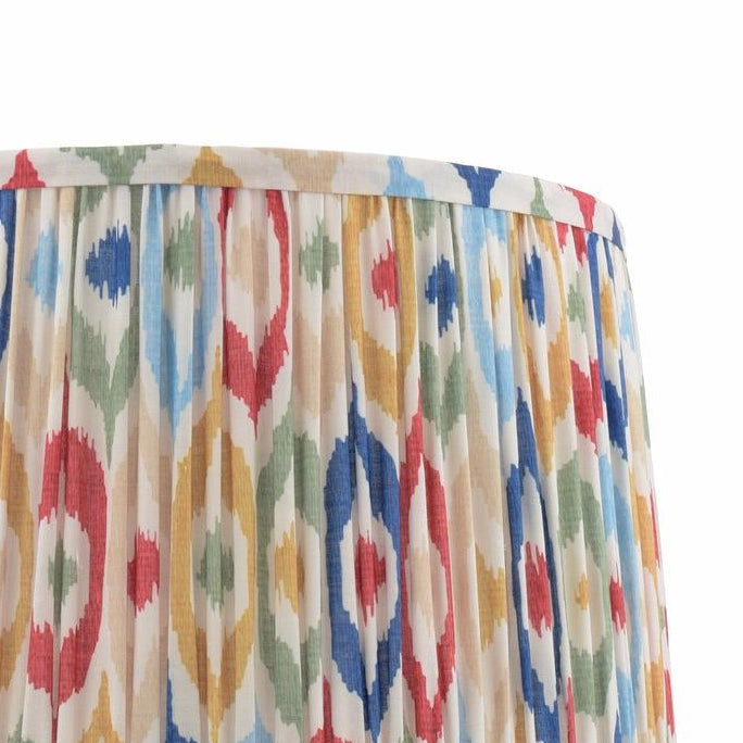 Pleated lampshade with a colorful ikat pattern in red blue yellow and green