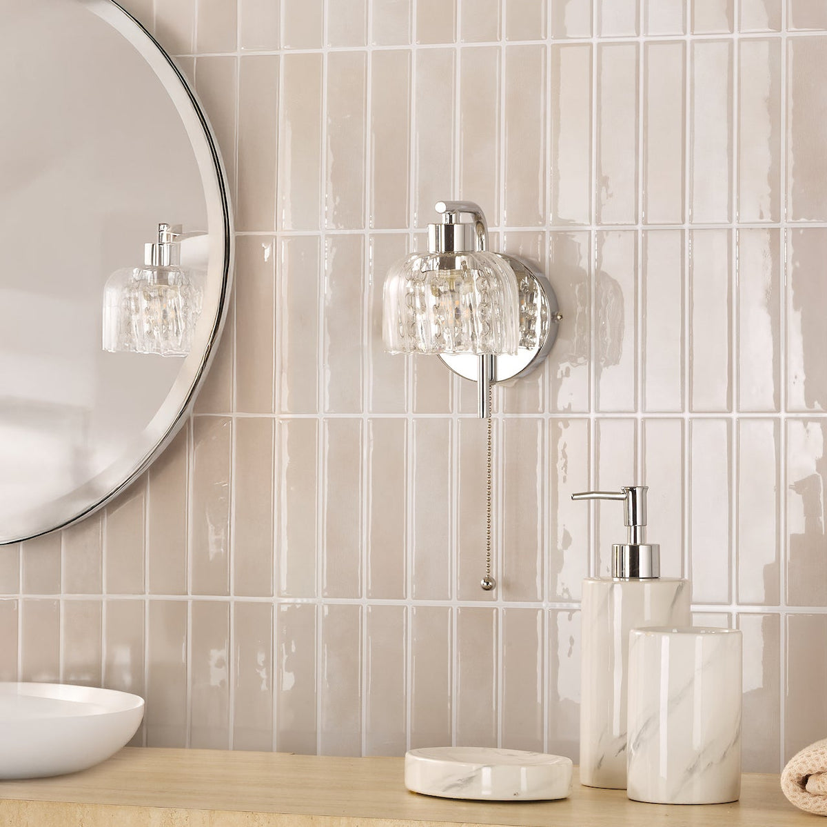 Bathroom vanity with round mirror, glass wall sconce, and marble soap dispenser set