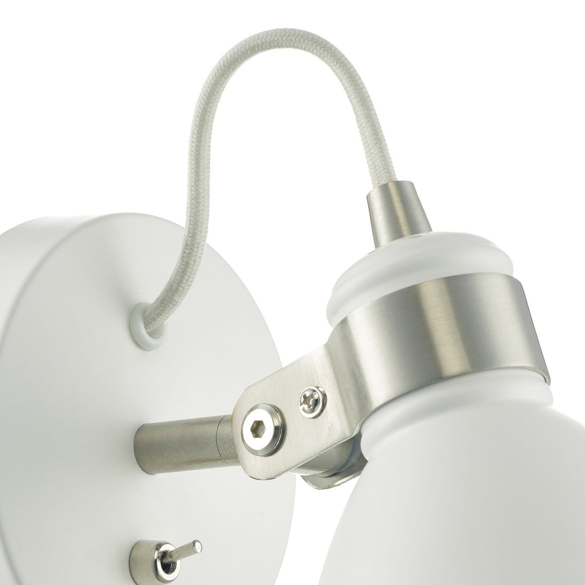 Close up of a white wall light with a flexible grey fabric cable and brushed steel details
