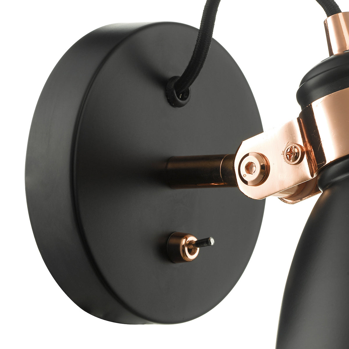 Close up of a black wall light with copper accents and a toggle switch