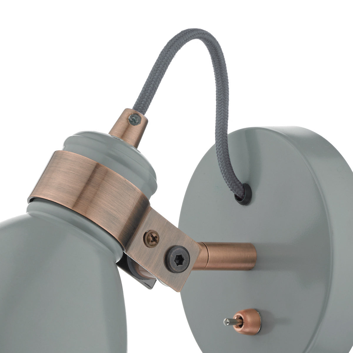 Close up of a grey wall light with a copper bracket and a grey braided cable