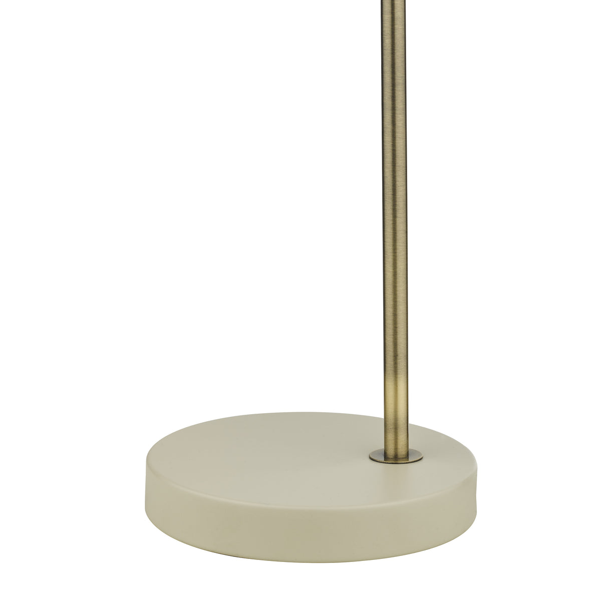 Close up of a floor lamp base, a round cream-colored base with a brass pole extending upwards