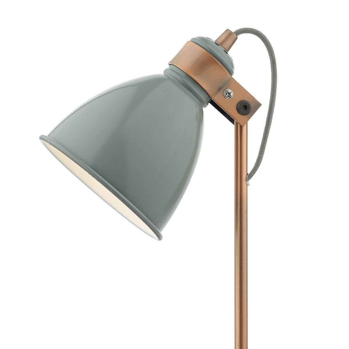 Close-up of a sage green and copper desk lamp with a braided cord.