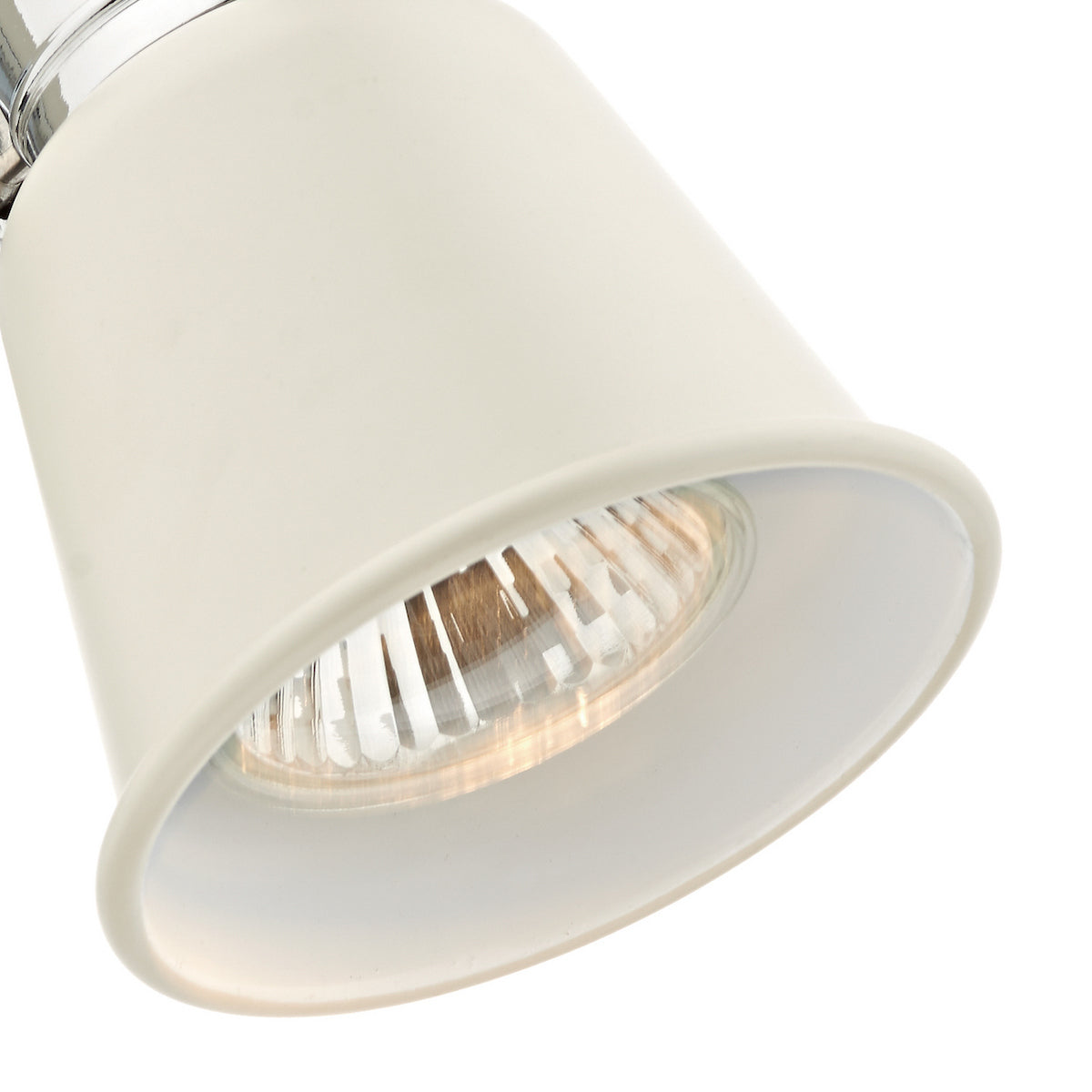 Close-up of a cream-colored spotlight with a clear bulb, angled downwards.