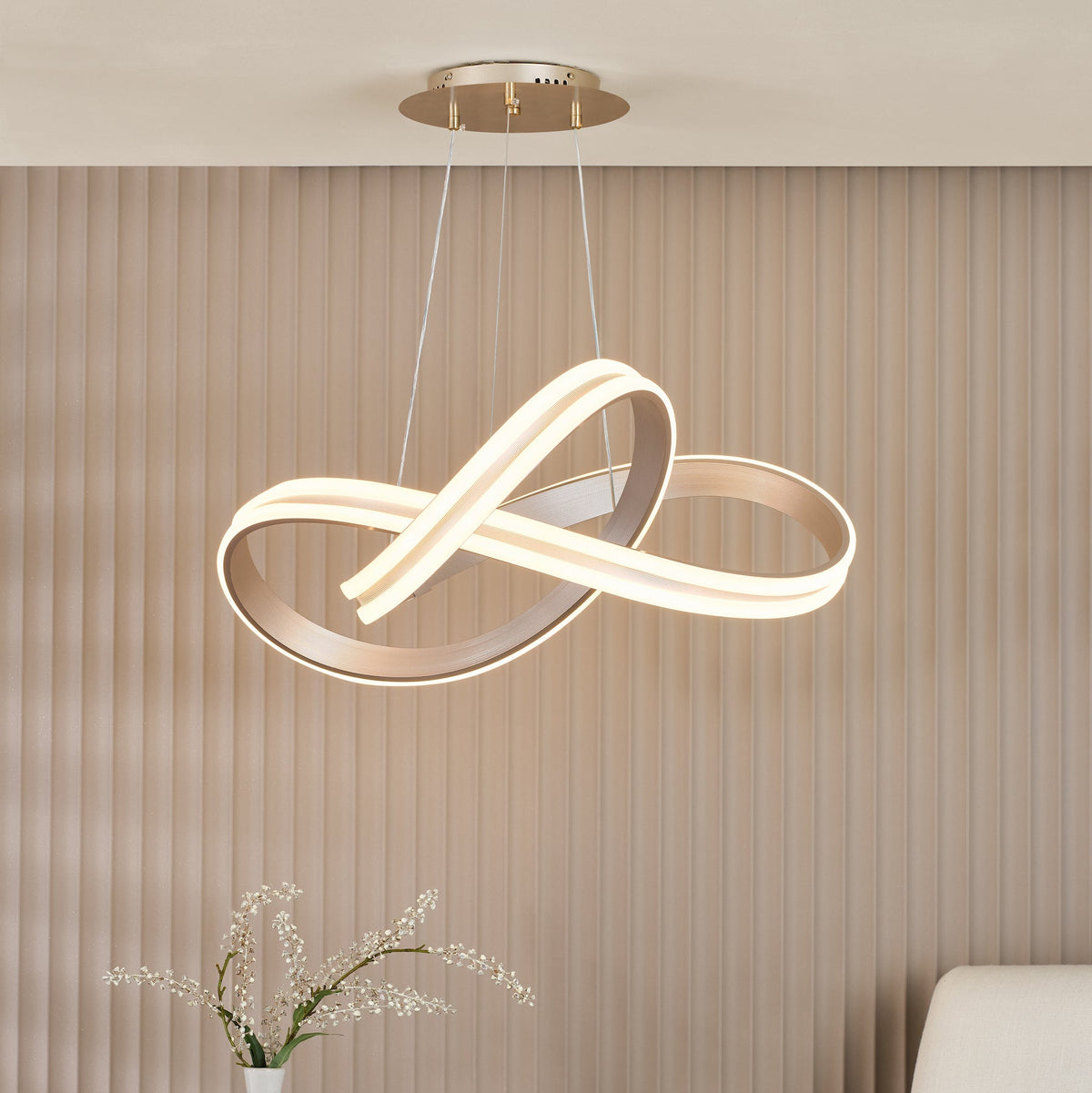 Modern LED pendant light with a gold finish and a unique infinity loop design