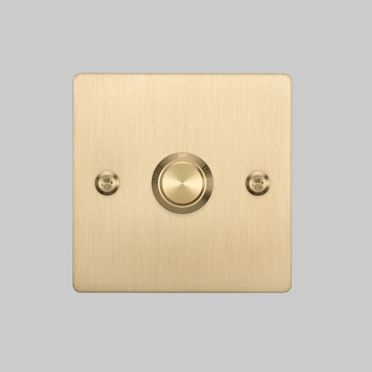 Brushed brass doorbell button on a square plate with visible screw heads