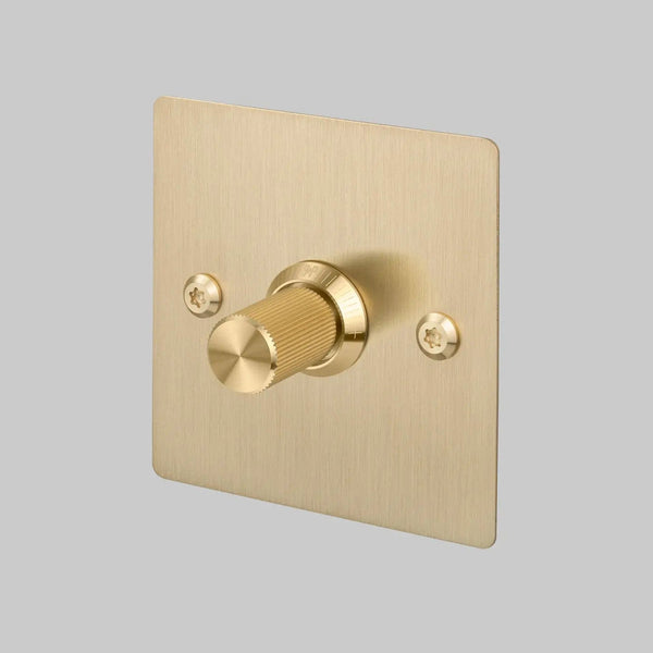 Brushed brass dimmer switch with a single ridged knob and two visible screws