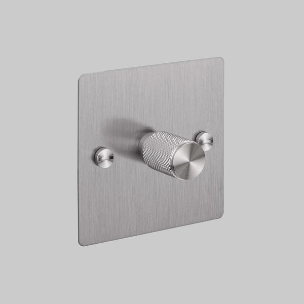 Brushed stainless steel dimmer switch with a single knurled rotary knob and two smaller circular fixings