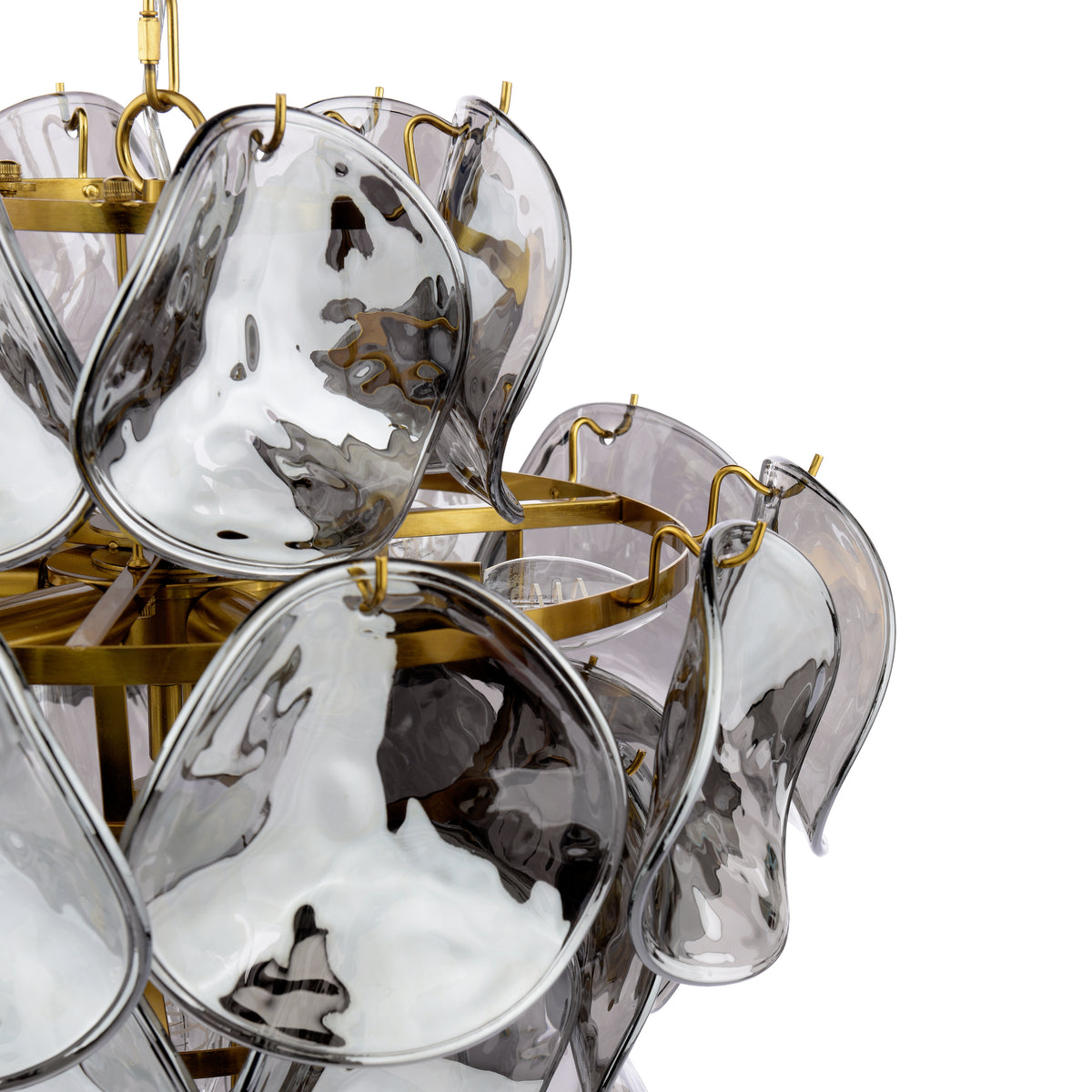 Close-up of a chandelier with clear, wavy glass panels and gold-colored metal accents