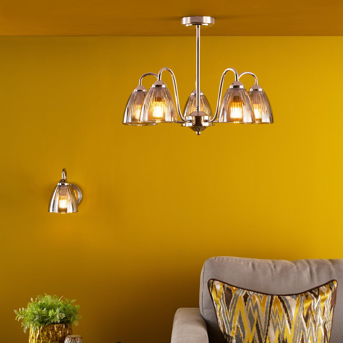 A five-light chandelier and a single wall light with fluted glass shades and polished chrome finish