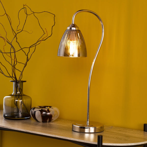 Polished chrome table lamp with a curved stem and a fluted glass shade