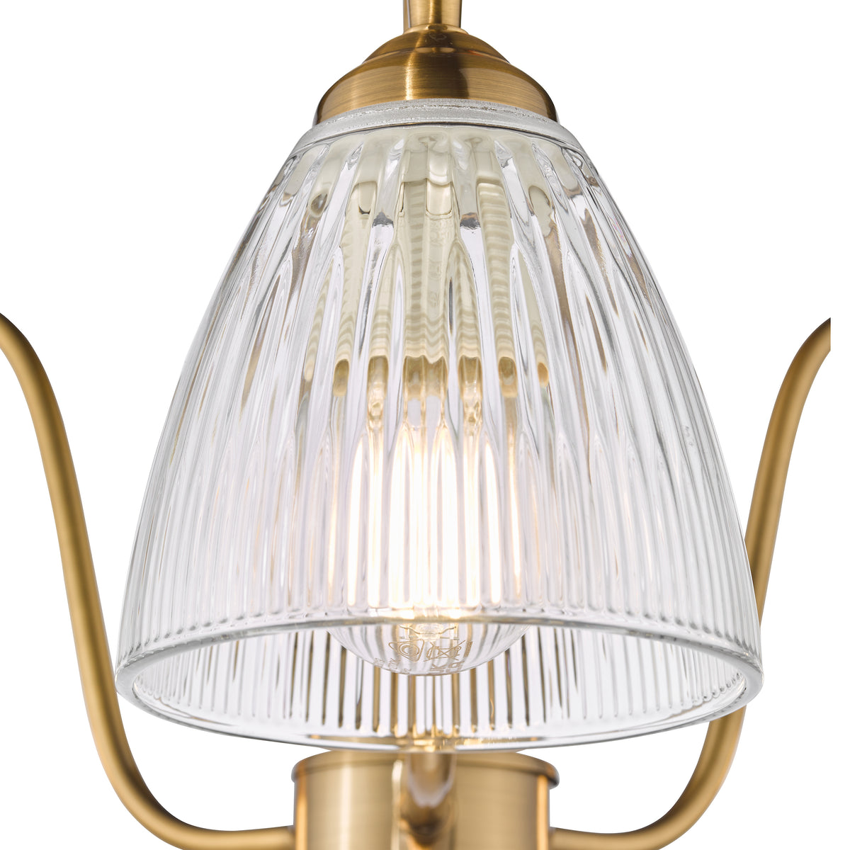 Close up of a brass chandelier with a clear ribbed glass shade and an illuminated bulb