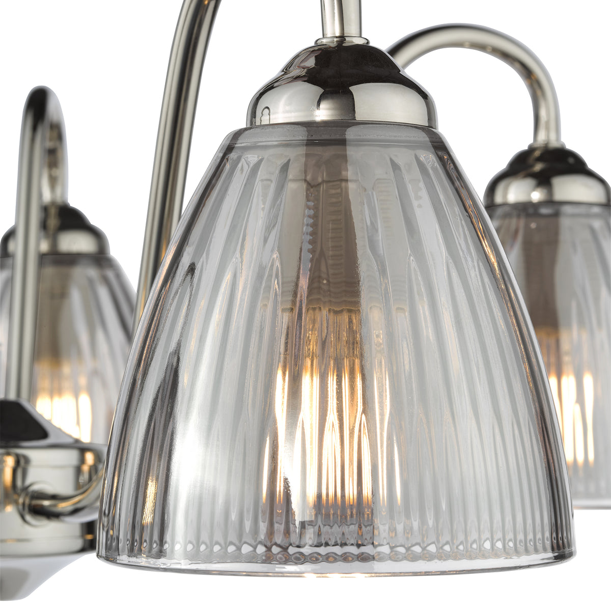 Close up of a brushed nickel chandelier with ribbed glass shades