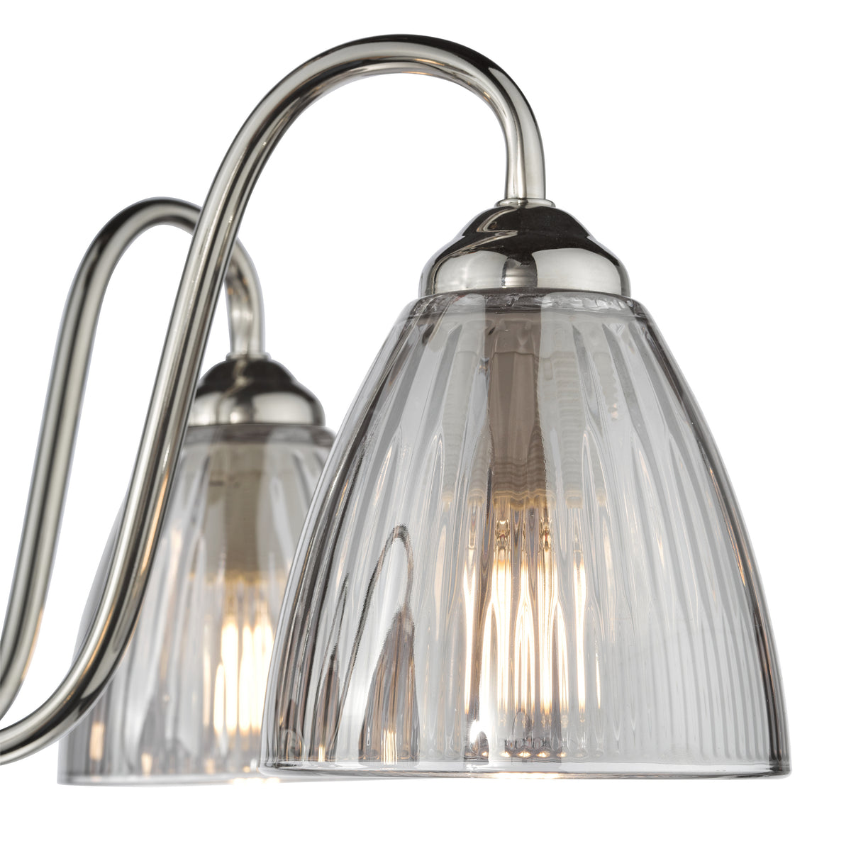 Close up of a three-light vanity light fixture with brushed nickel finish and clear ribbed glass shades