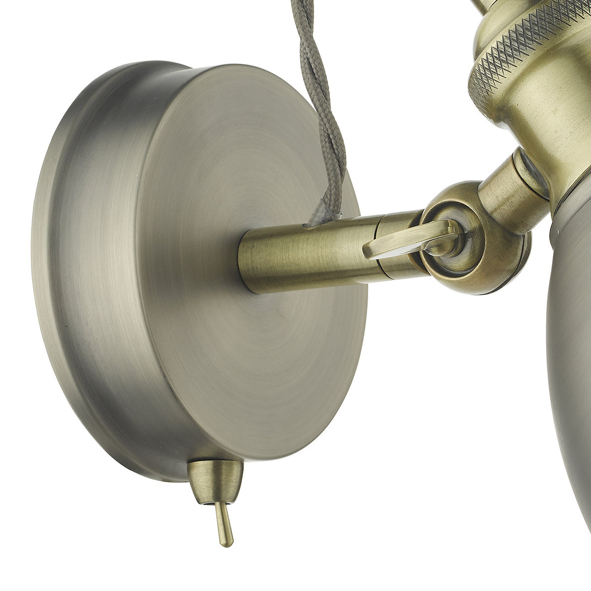 Close-up of a brass wall light fixture with a round base and an adjustable arm.