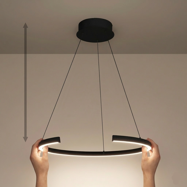 Hands adjusting the height of a black circular pendant light with an illuminated inner edge