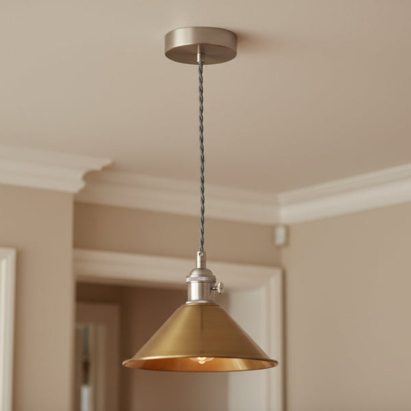 Brushed brass pendant light with a conical shade and a grey twisted fabric cable, against a white background.