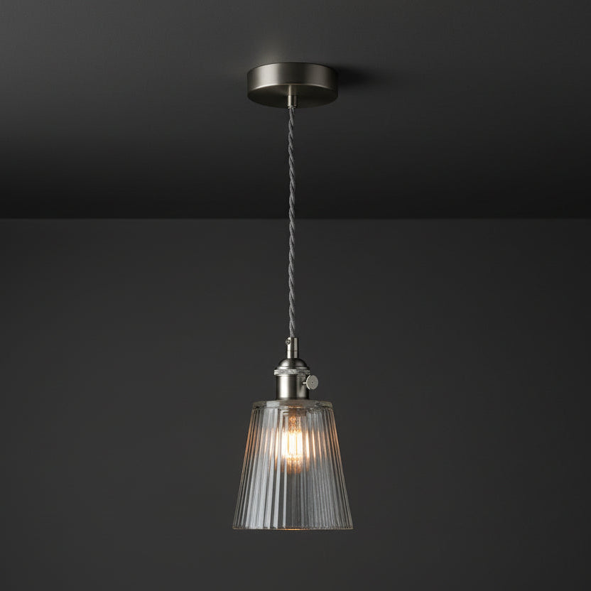 Brushed steel pendant light with a clear, fluted glass shade and a grey braided cable.