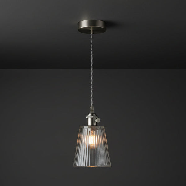 Brushed steel pendant light with a clear, fluted glass shade and a grey braided cable.