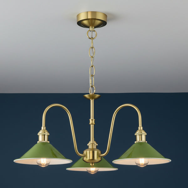 Three-light chandelier with green metal shades and brass accents.