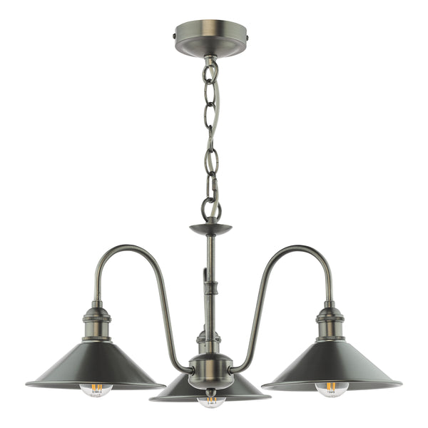 A three-light chandelier in an antique brass finish with cone-shaped shades and exposed filament bulbs.
