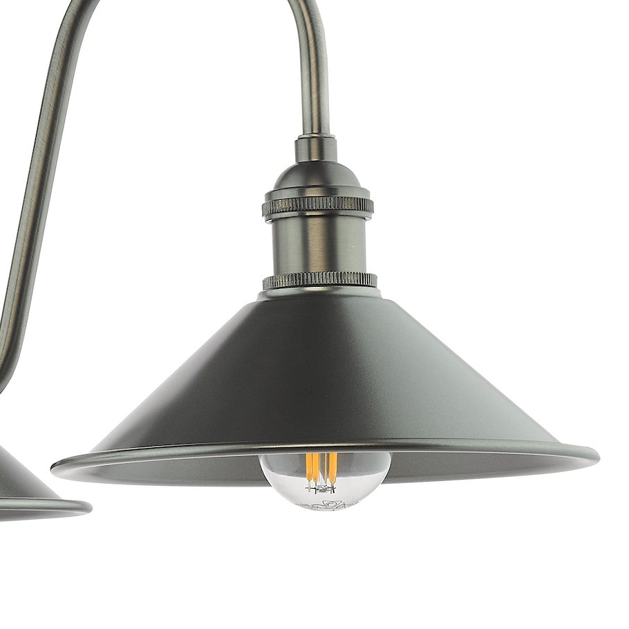 Close up of a brushed steel light fixture with a clear bulb