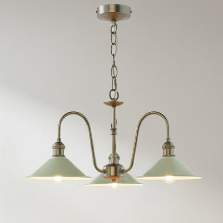 Three-light chandelier with antique brass finish and pale green metal shades, hanging from a chain.